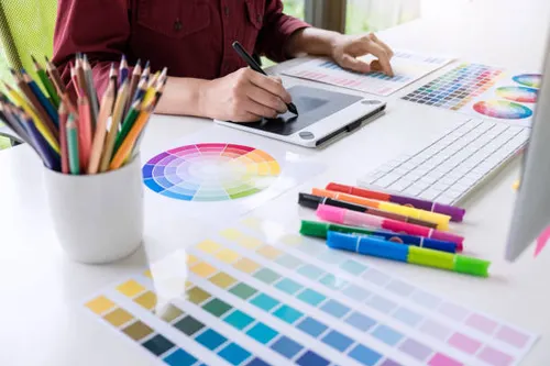 image of female creative graphic designer working on color selection and drawing on graphics